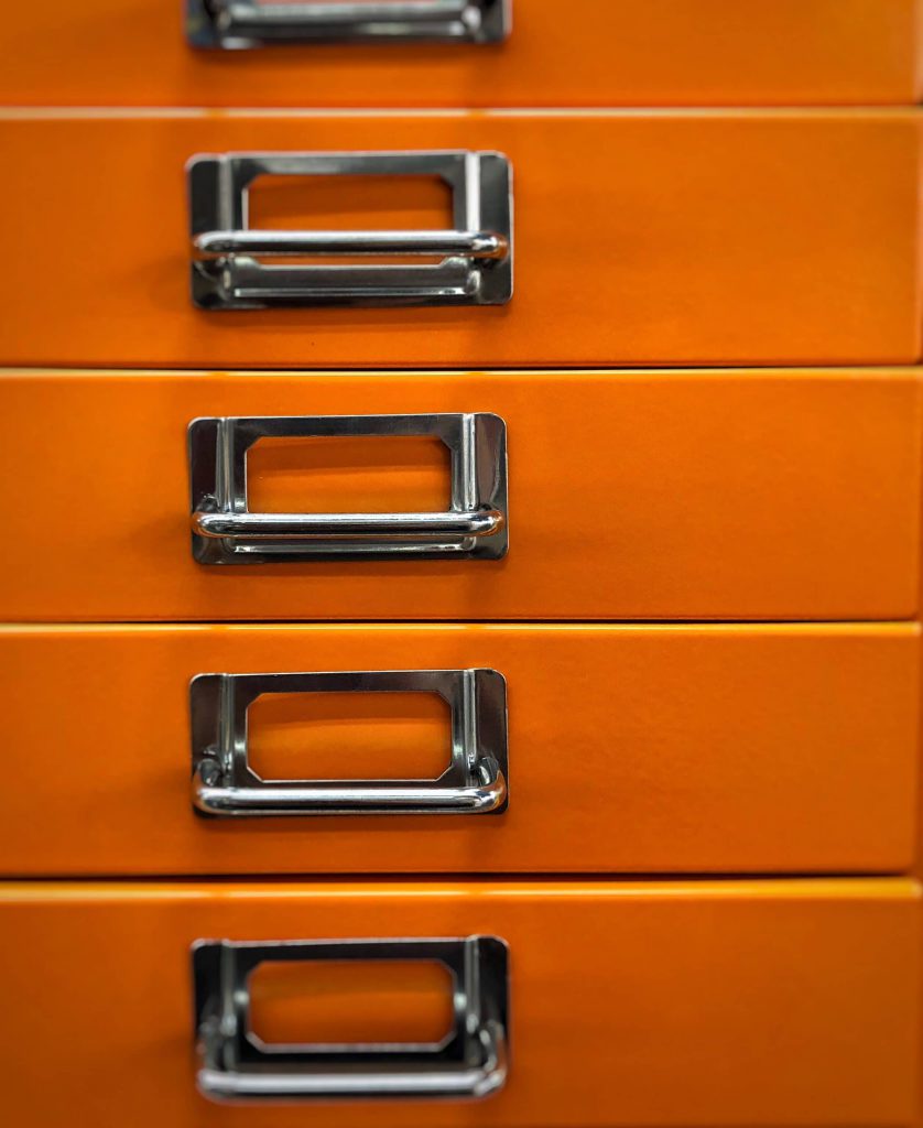 Orange Filing Cabinet with five silver metal handles.