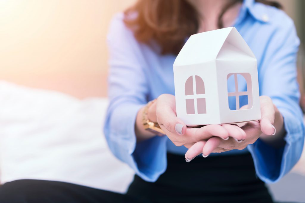 Agent holding a house in her hands